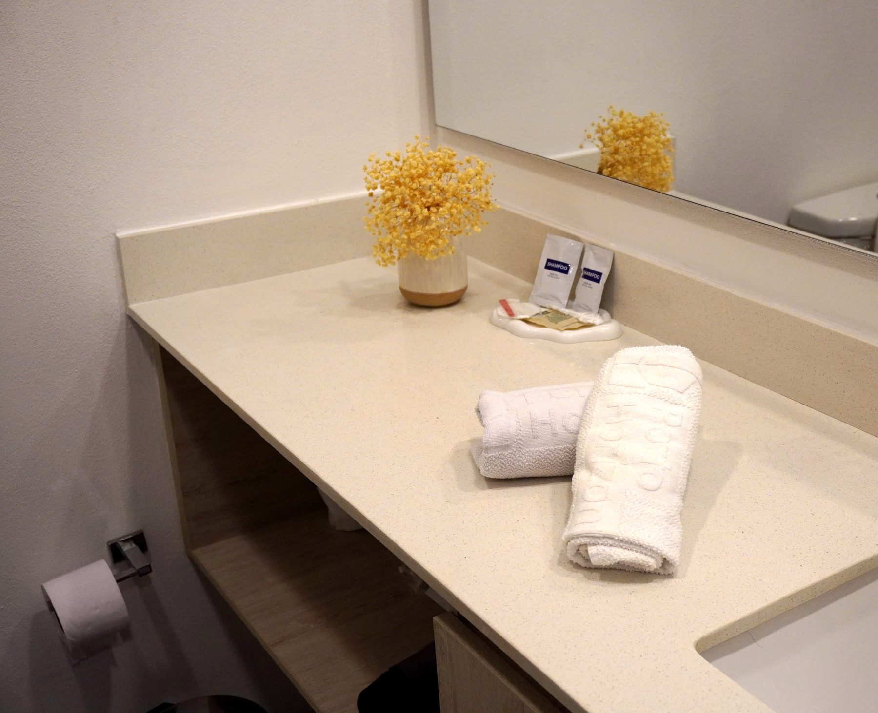 Mesa redonda con flores y libro de Santa Marta